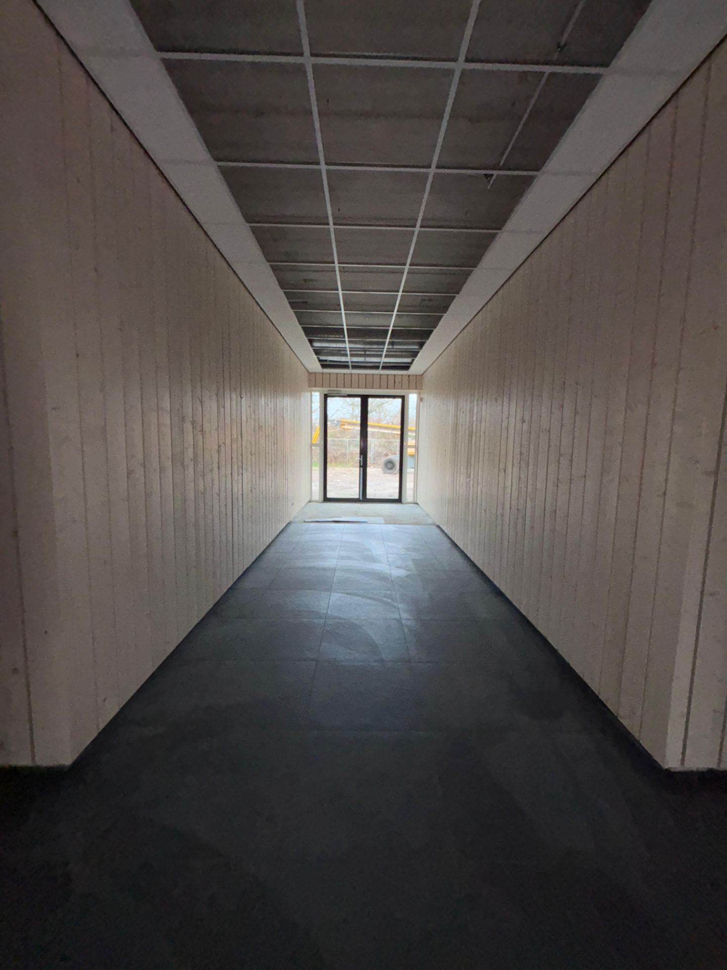 Gang met houten wandpanelen gemonteerd door SFD Timmerwerken